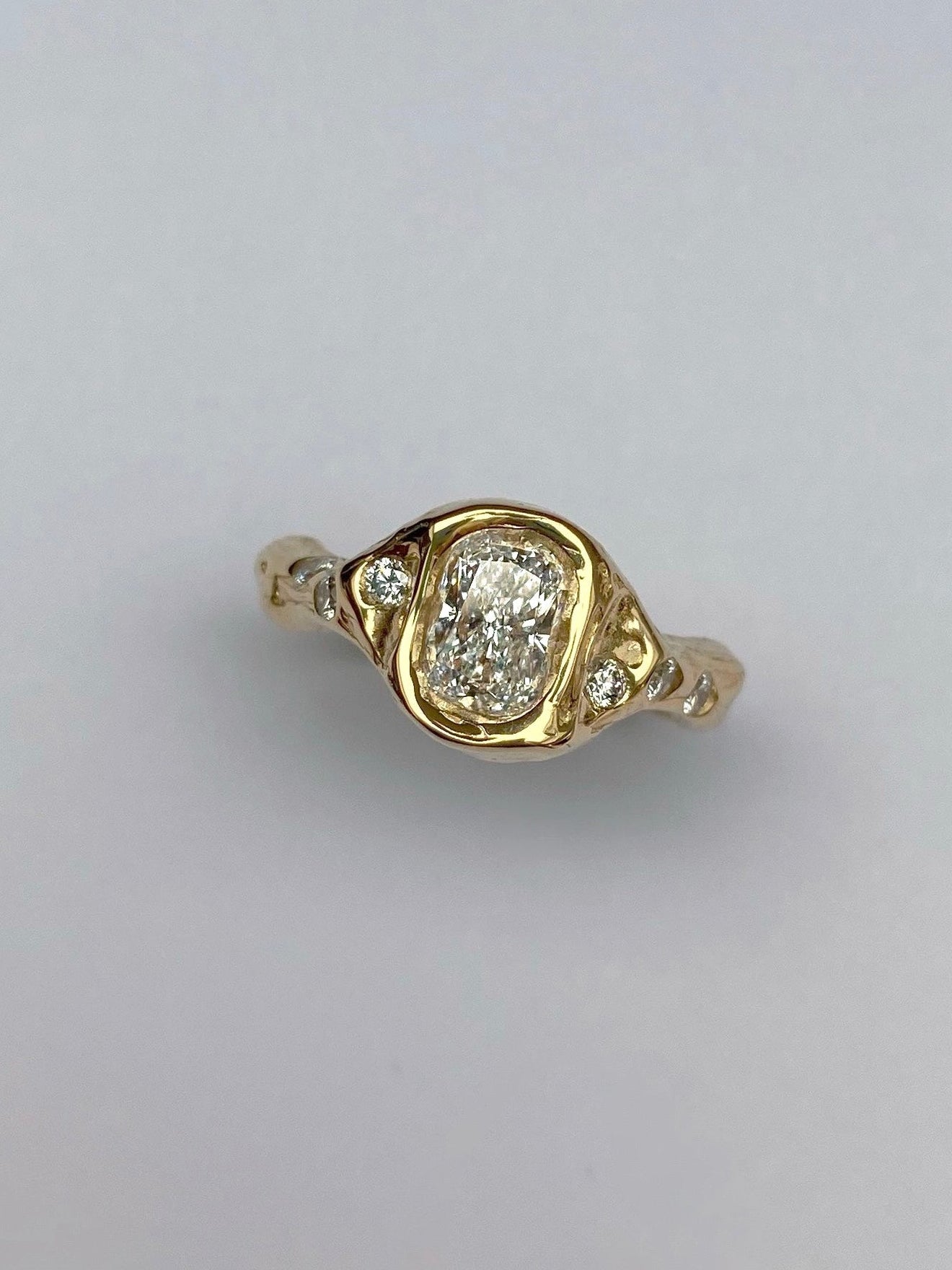 chunky 18 karat gold engagement ring with cushion diamond